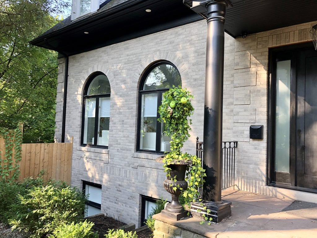 Light brick home with black trim showing a dualtone masonry finish